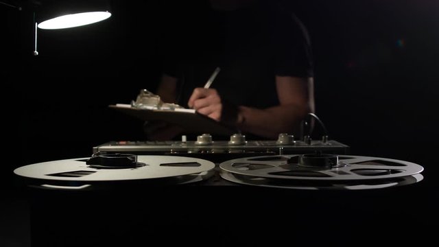  Retro Analog Quarter Inch Tape Recorder Being Operated in a Darkened Room