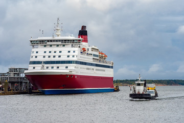 Fototapeta premium Finland. Helsinki. The cruise port. Vessels of different sizes. A big cruise ship and a small speedboat. Voyage. Shipbuilding. Cruises in Scandinavia.