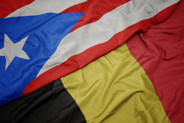 waving colorful flag of belgium and national flag of puerto rico.