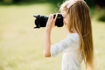 young girl takes camera outdoors , child with a camera