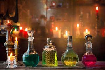 Obraz na płótnie Canvas magic potions in bottles on wooden background