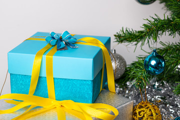 Christmas mood. Gifts packed in blue and silver color gift wrapping located on a wooden table and on a white background. Time to give presents. Close-up.