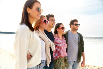 friendship, leisure and people concept - group of happy friends on beach in summer