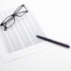Accounting business concept. Desktop with glasses, spreadsheet and pen.
