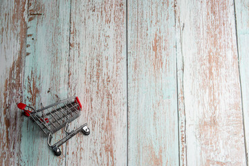 Mini shopping trolley on a wooden background