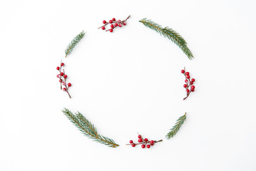 winter holidays, new year and decorations concept - frame of fir branches with red berries on white background