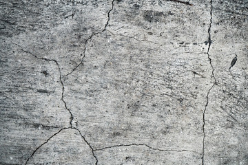 Texture of an old cracked concrete wall. Background image of a worn gray concrete surface