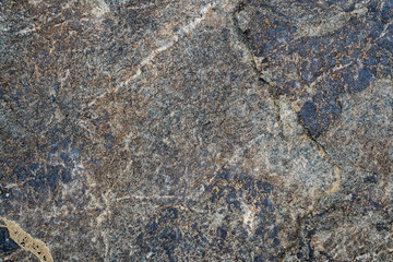 The texture of the stone overgrown with moss. Background image of a boulder