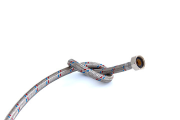 The water inlet hose tap metal braid, tied in a knot isolated on white.