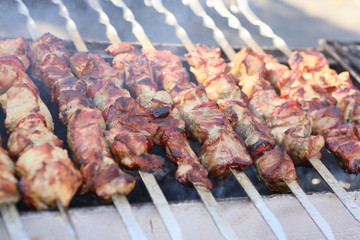 Mixed grilled meat platter. Assorted delicious grilled meat. The closeup of some meat skewers being grilled in a barbecue. grilled meat skewers, barbecue.