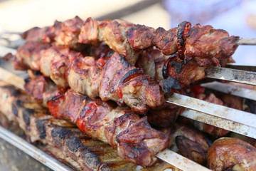 Mixed grilled meat platter. Assorted delicious grilled meat. The closeup of some meat skewers being grilled in a barbecue. grilled meat skewers, barbecue.
