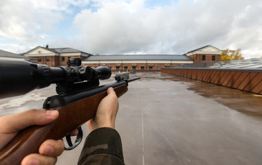 virtual reality game and violence concept - POV of male hands shooting with air rifle outdoors
