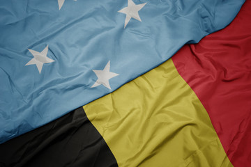 waving colorful flag of belgium and national flag of Federated States of Micronesia .