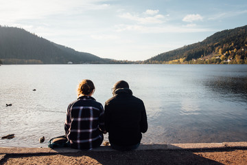 un couple d'amoureux devant le lac de Gérardmer. Des gens assis devant un lac. Des amoureux...