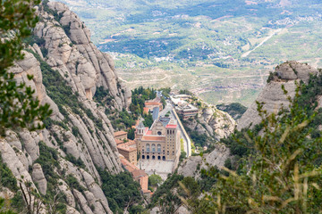 Fototapeta na wymiar Santa Maria de Montserrat Abbey in Monistrol de Montserrat Monastery view from above located nearby from Barcelona in Catalonia, Spain