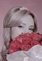 portrait of a blonde girl with a bouquet of orange roses