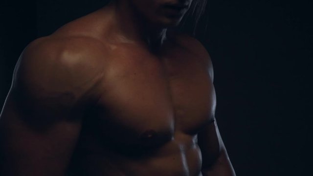 Fitness tanned guy showing biceps, close up, slow motion