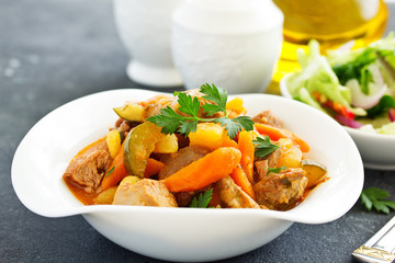 Beef stew with tomato sauce in a pan on wooden background. azu.
