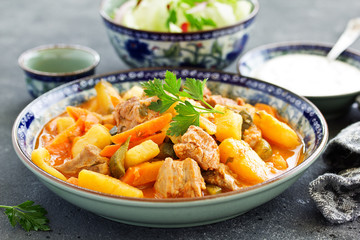 Beef stew with tomato sauce in a pan on wooden background. azu.