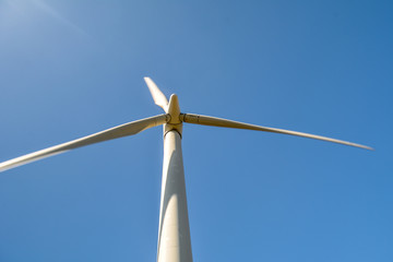 Close-up and low angle view of spinning blades of a wind turbine