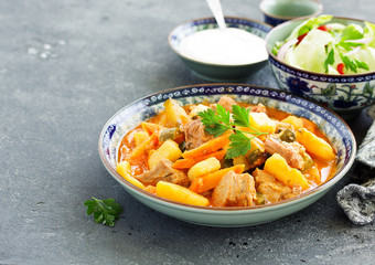 Beef stew with tomato sauce in a pan on wooden background. azu.