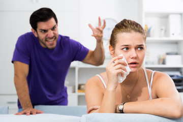 Fototapeta premium Upset woman at table with disgruntled man behind