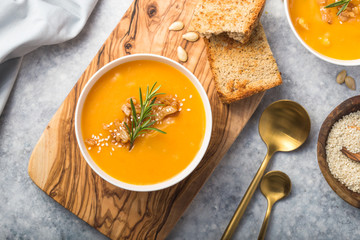 Homemade Autumn Butternut Squash pumpkin cream Soup with Bread and seeds. top view