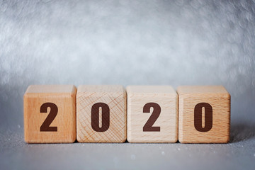 2020 new year concept: wooden cubes on silver background with beautiful bokeh