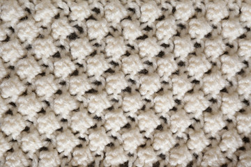 Cropped close up shot of seamless woolen knitting pattern of fall / winter season warm sweater, clearly visible fiber texture of stylish hipster knitwear clothing. Background, copy space, top view.