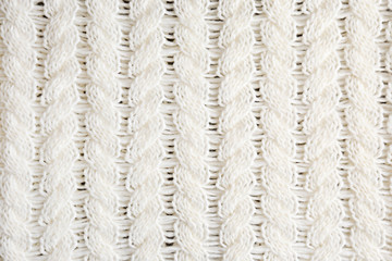 Cropped close up shot of seamless woolen knitting pattern of fall / winter season warm sweater, clearly visible fiber texture of stylish hipster knitwear clothing. Background, copy space, top view.