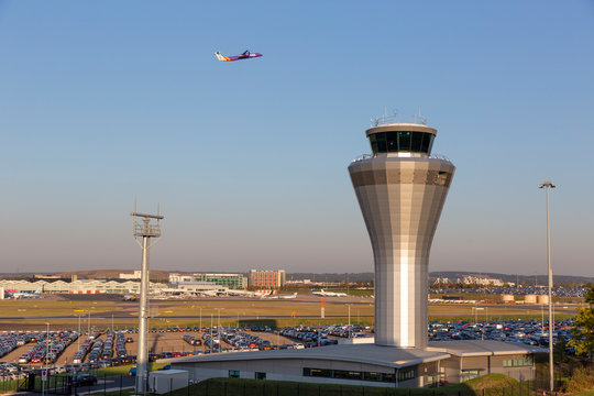 BIRMINGHAM, UK - OCTOBER 17, 2018: General wide view of Birmingham Airport in the Midlands, England with a Flybe aircraft passing the distinctive, metallic control tower.