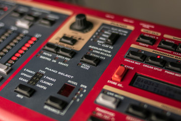 Button panel of a classic red stage synthesizer, with various controls and displays