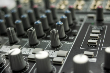 Primer plano de una mesa de mezclas de sonido analógica con ocho canales