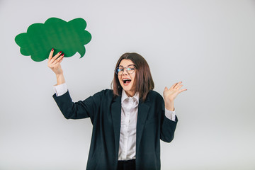 Lovely young businesslady standing with green cloud-like speech bubble, throwing her hand, looking shocked and amazed.