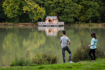 un jeune couple pêchant et pêchent sur un lac avec une cabane sur pilotis