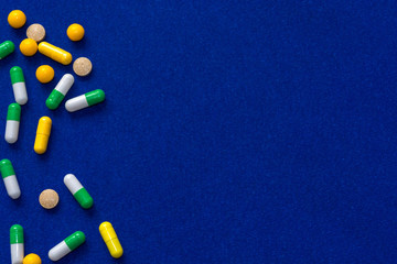 Medical pills. Color capsules medication. Blue background. Health care concept. Free space for text. Medicines. Many different pills. Chemical industry.