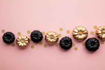 Gold and black pumpkins on pastel pink. Flat lay thanksgiving composition