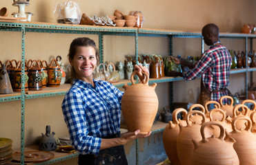 Female arranging clay goods on shelves
