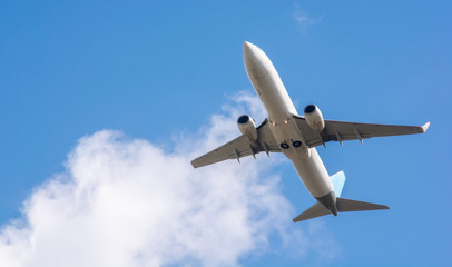 A large white passenger plane takes off. Cargo and passenger transportation. Flight to the summer resort. Clear blue sky. Airplane in the sky.