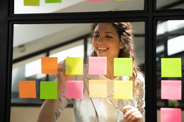 Businesswoman writes creates personal tasks list on sticky notes