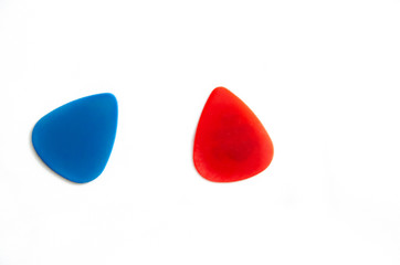 Red and blue guitar pick for guitar. Plectrum for playing stringed instruments. Macro. On white background