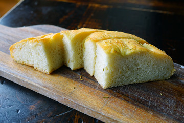 Slices of fresh focaccia bread on a wooden board