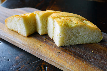 Slices of fresh focaccia bread on a wooden board