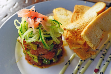 Plate of raw tuna poke with fresh avocado and pickled ginger