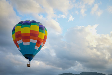 Coroful Hot Air Ballon Flying In The sky with clouds and mountain background