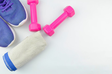 Fitness concept background with sneakers, dumbbells and towel. Top view with space for your text.