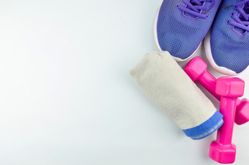 Fitness concept background with sneakers, dumbbells and towel. Top view with space for your text.