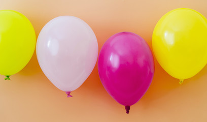 Colorful balloons on orange background