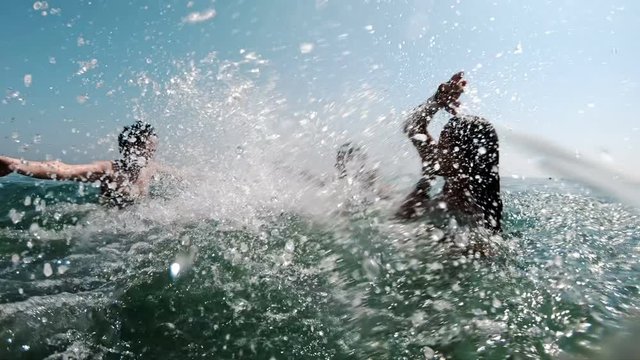 Slow motion of a family splashing each other in the sea and having fun on vacation