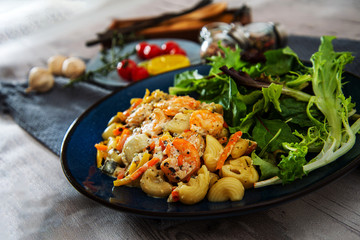 Cooked pasta with peeled shrimp, coconut milk sauce and broccoli